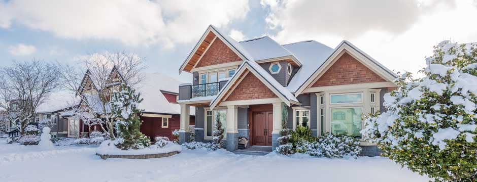 House and surrounding area covered in deep snow